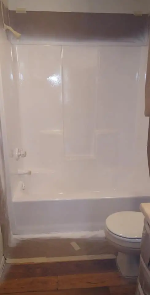 Fiberglass tub and shower unit resurfaced in bright white with molded shelves