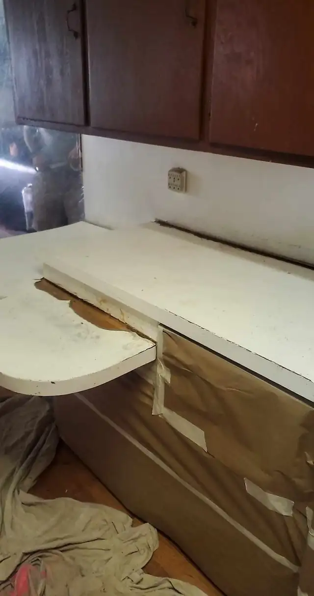 Bathroom vanity countertop masked with paper during resurfacing, coated in a light stone finish